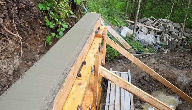 freshly poured footing with rebar for a retaining wall