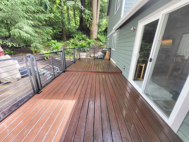 a deck with metal railings and fresh stain